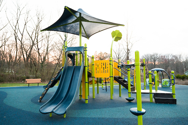 A colorful outdoor playground with blue slides and multiple climbing structures.